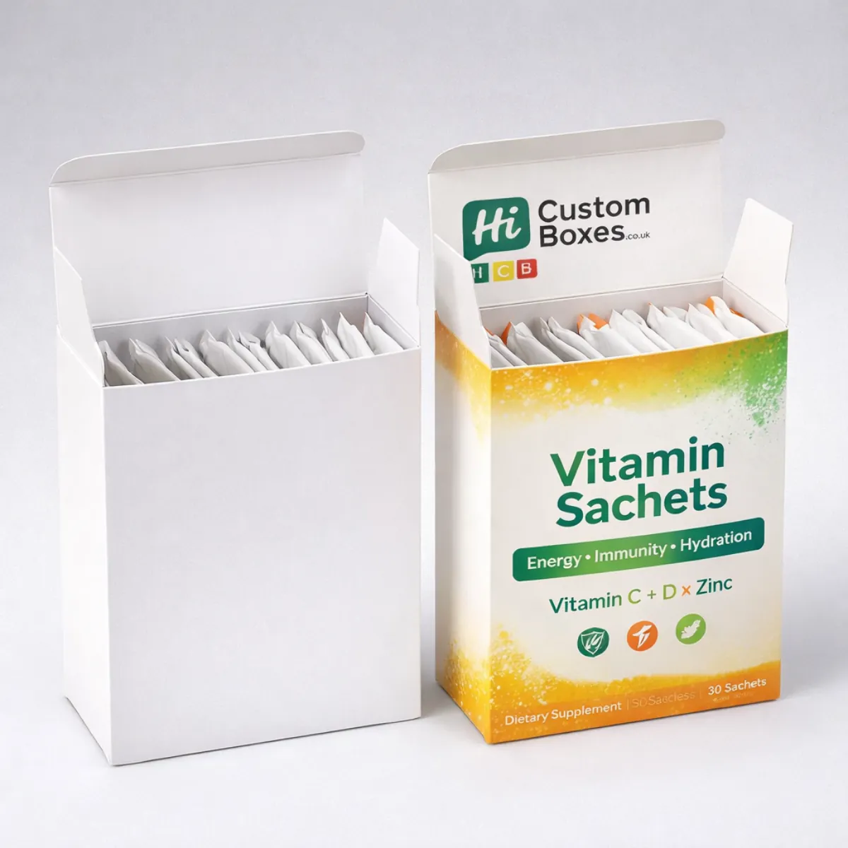 Two open cardboard boxes packed with vitamin sachets, one plain white and one with vibrant branding.
